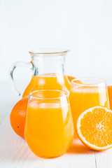 Close-up of a glass of orange juice with oranges fruits on wooden and stone background. Vitamins and minerals. Healthy drink and beverage concept.