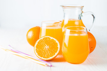 Close-up of a glass of orange juice with oranges fruits on wooden and stone background. Vitamins and minerals. Healthy drink and beverage concept.