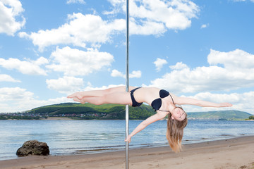 dancer on pole performs acrobatic