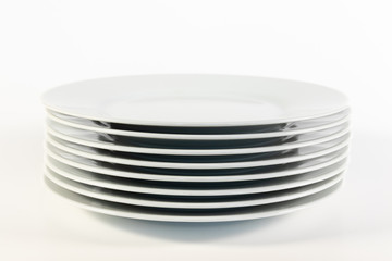 Gestapelte weiße Porzellanteller isoliert vor weißem Hintergrund