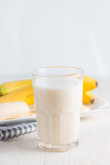 Fresh Made Chocolate Banana Smoothie on a wooden table. Selective focus. Milkshake with almonds. Protein diet. Healthy food and drink concept.