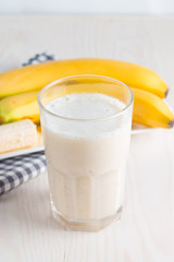 Fresh Made Chocolate Banana Smoothie on a wooden table. Selective focus. Milkshake with almonds. Protein diet. Healthy food and drink concept.