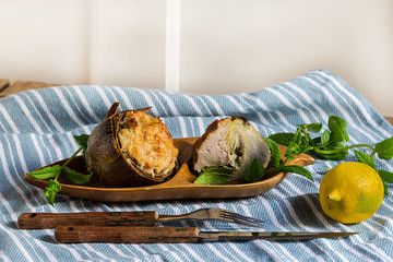 Stuffed artichokes on wooden plate, rustic style
