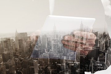 Businessman scrolling on his digital tablet against new york skyline