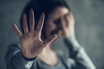 Oppressed woman shows by hand sign stop.