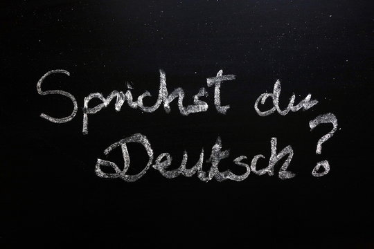 Sprichst du Deutsch (do you speak German) question written on chalkboard