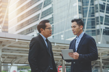 two attractive business man using touching pad on smartphone and tablet technology connecting social online talking with discussion about business strategy growing.
