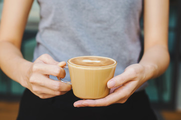 beautiful girl hold serving hot coffee cup for your delicious freshness.