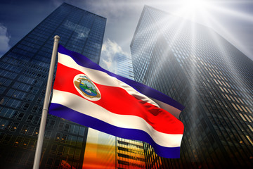 Costa rica national flag against low angle view of skyscrapers at sunset