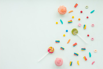 Colorful candies on pastel turquoise background. Flat lay, top view