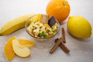 Bowl of healthy fresh fruit salad with tropical fruit background