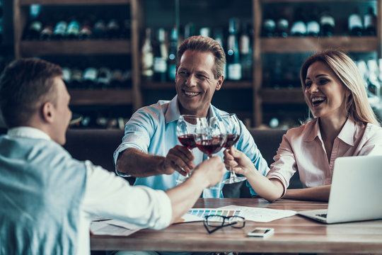 Group Of Business People Cheering With Wine Glass At Cafe.