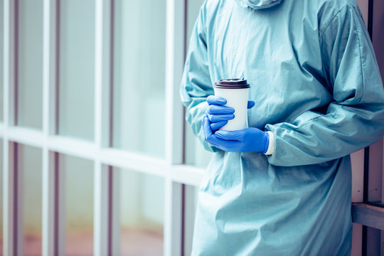 Doctor In Blue Scrubs Relaxing With Coffee Break.