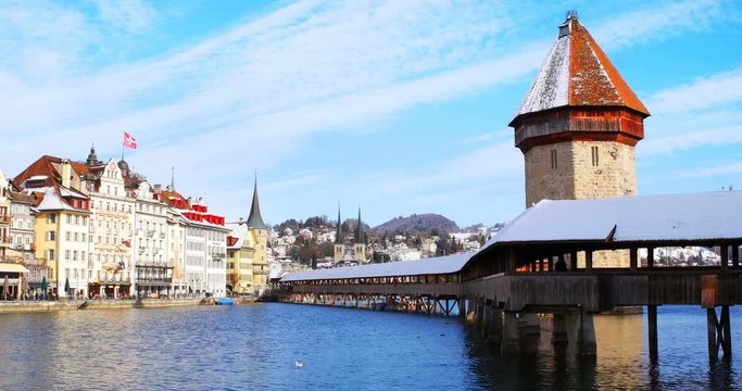 Lucern, Switzerland. Chapel Bridge - a famous landmark in Lucern, Switzerland during the sunny day with the city at the background. various hotels and restaurants