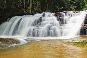 Fototapeta na wymiar The beauty of the lush mountain stream waterfall