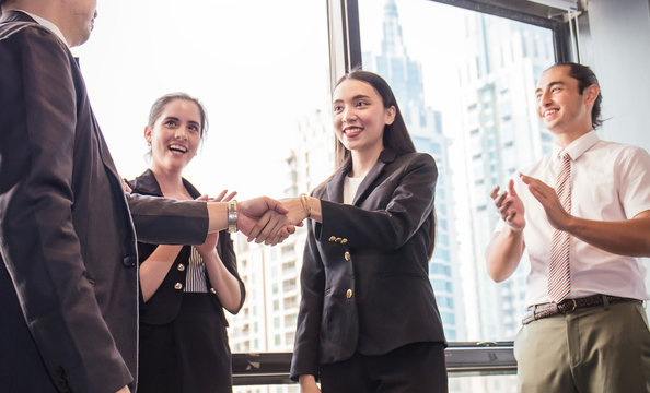 Group Of Multicultural Employees Talking And Having Fun In The Business Meeting, Two Business Man Shaking Hands With Other Employee Clapping Hands,  Banner Billboard Business Teamwork Success Concept.