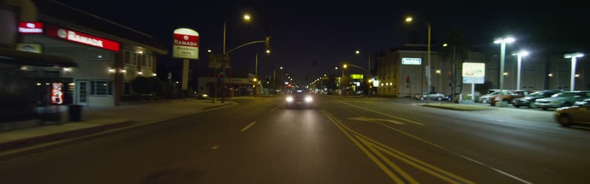 Rear view of a Driving Plate: Car travels on East Colorado Boulevard in Pasadena, California at night, crossing Craig Avenue, pausing near Sierra Madre Boulevard, and continuing on to make a left turn at Sunnyslope Avenue.