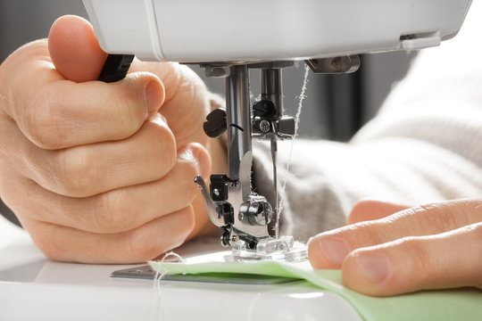 closeup of hands working on sewing machine