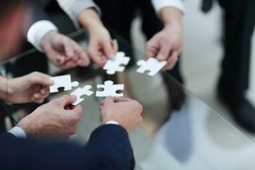 Business people holding jigsaw puzzle.