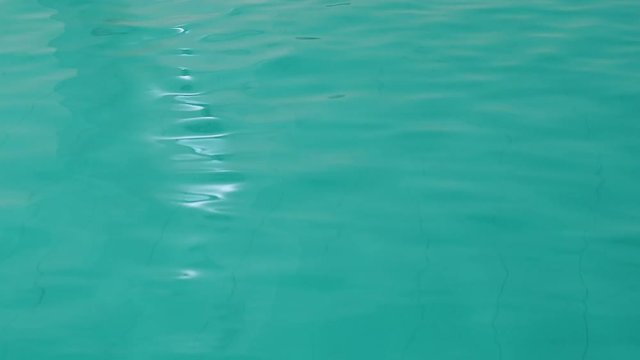Water surface moving in a green swimming pool