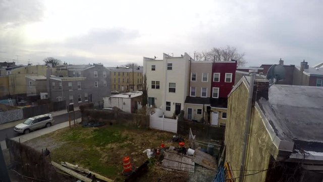 Time Lapse shot of an empty lot and houses in the urban Philadelphia neighborhood of Fishtown on an overcast day.