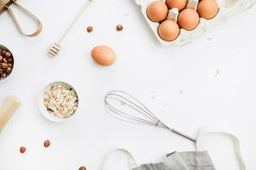 Flat lay, top view of raw healthy food ingredients. Cutting board, hazelnuts, eggs, cereals. Cooking concept.