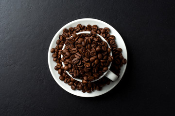 Roasted coffee beans inside white coffee cup