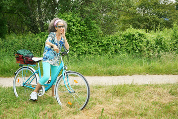 Woman with bike smiling nature