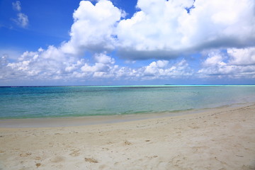 Beautiful view of white sand beach. Turquoise water and blue sky with white clouds. Indian Ocean, Maldives.