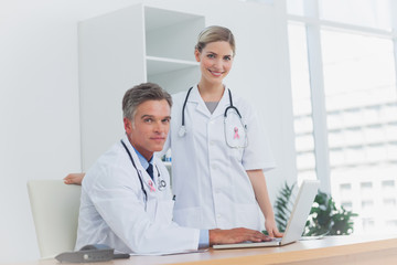 Medical team at the office wearing breast cancer awareness ribbon