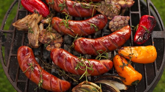 Grilled sausages and vegetables on a grilled plate, outdoor. Grilled food, bbq, 4K
