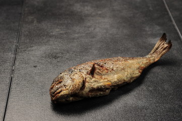 baked fish on a dark background