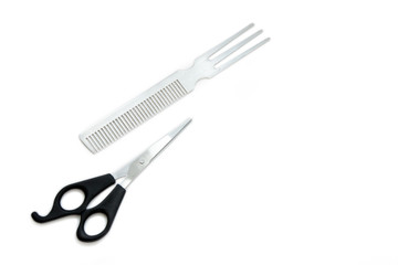 Hairdressing scissors with black handles and a metallic shiny comb on a white background. Close image.