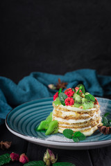 Delicious cake with fruit and mint decoration on black background