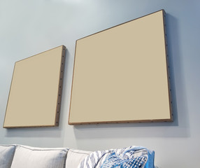 Two Blank Beige Picture Frames on a Wall above a Couch