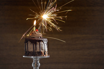 Obraz premium Birthday cake with candle and sparkler