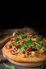 Pizza with chicken, arugula, cheese and onions on wooden rustic table