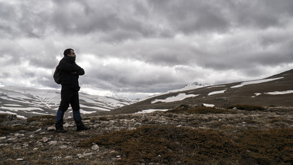Obraz premium Man trekking in part snowy mountains in cloudy and gloomy weather. Bolu Köroğlu Mountains Spring View