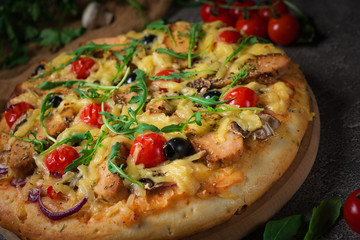 Pizza with chicken, arugula, cheese and onions on wooden rustic table. Top view