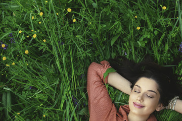 Girl lying in grass close-up from above