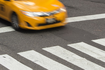 Yellow Taxi Cabin in motion on the pedestrian strips in Times Square, New York City, USA.