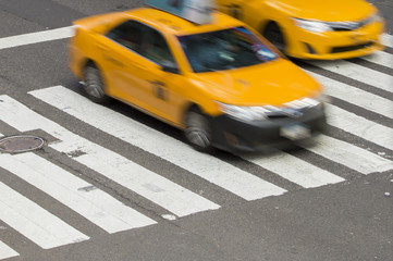 Yellow Taxi Cabin in motion on the pedestrian strips in Times Square, New York City, USA.