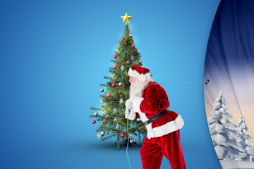 Santa claus pulling rope against snowy landscape with fir trees