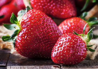Fresh red strawberry, vintage wooden background, selective focus