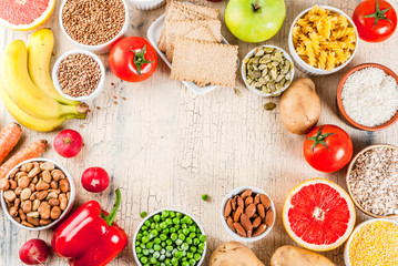 Diet food background concept, healthy carbohydrates (carbs) products - fruits, vegetables, cereals, nuts, beans, light concrete background  copy space  frame above