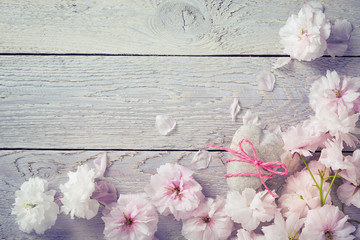 Cherry blossom and stone heart on wooden background  -  Greeting card