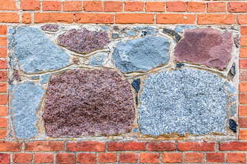 Wall of natural stone and red brick