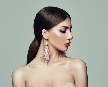 Stylish Woman with Ponytail Hairstyle and Pink Earrings