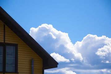 house against a blue sky with blue white clouds