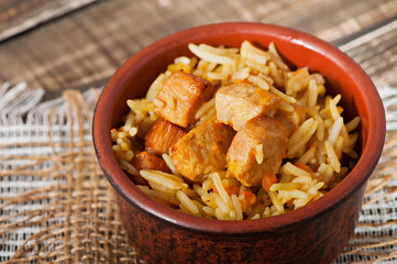Food - fried pieces of turkey poultry meat with rice, onions, carrots and seasonings.